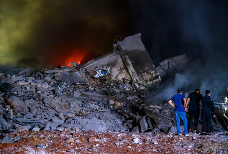 Rescue workers gather at the site of a massive Israeli air attack on pro-Iranian Hezbollah headquarters in the southern suburbs of Beirut. Marwan Naaman/dpa