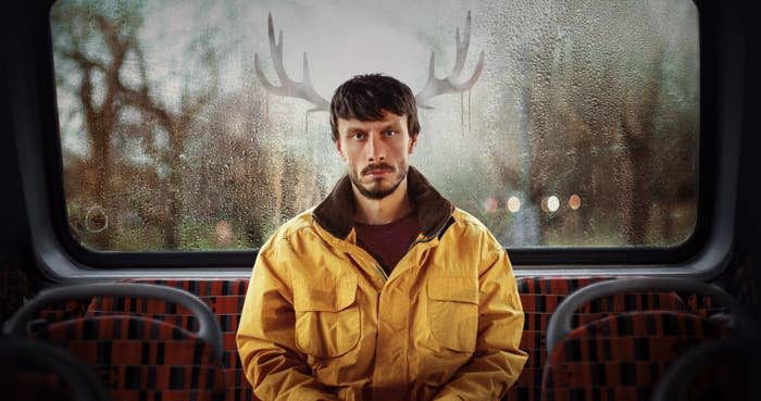 Richard Gadd in a yellow jacket on a bus with antlers digitally added to his head