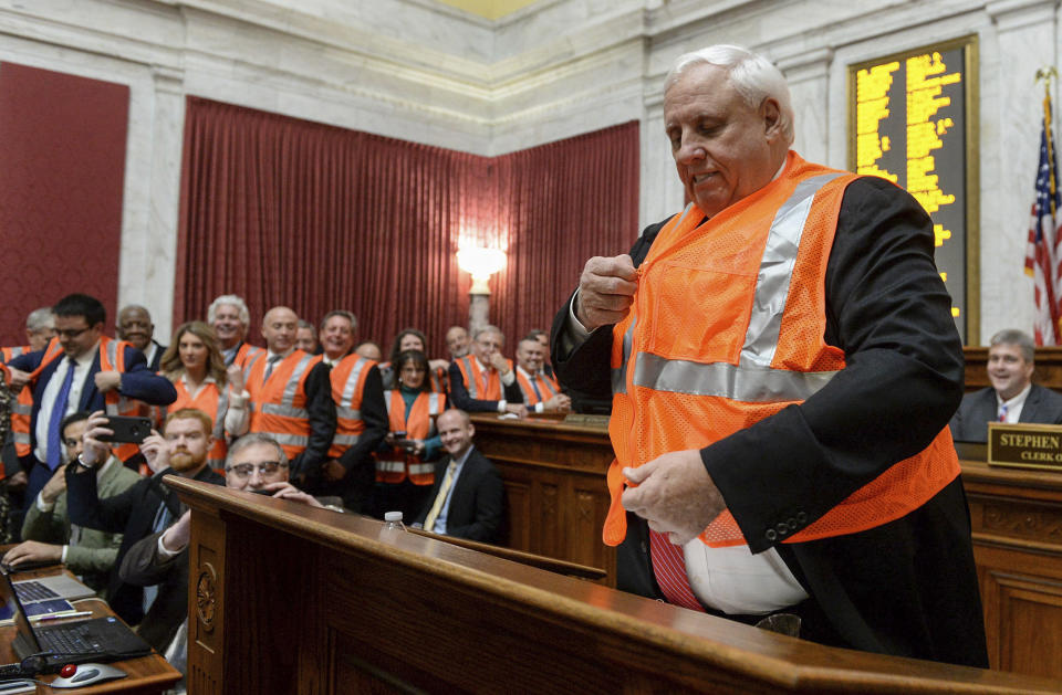 FILE - West Virginia Gov. Jim Justice puts on a Department of Highways safety vest during his annual State of the State speech in the Capitol's House chambers, Jan. 8, 2020, in Charleston, W.Va. The two-term governor is set to give his final State of the State speech to lawmakers on Wednesday, Jan. 10, 2024. (Chris Dorst/Charleston Gazette-Mail via AP, File)