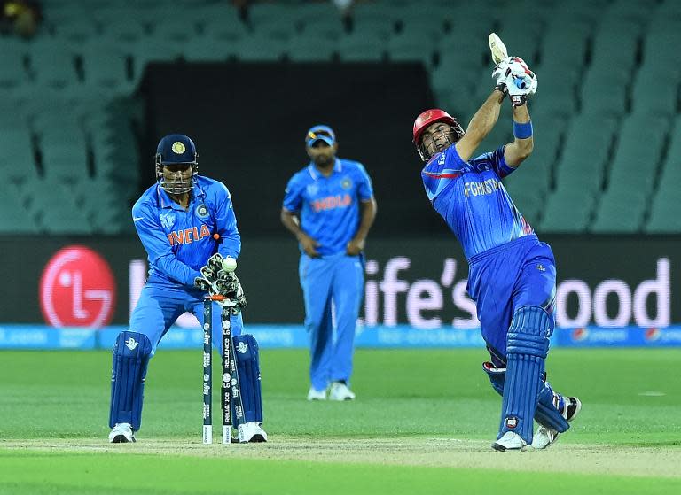 Afghanistan's Mohammad Nabi (R) is bowled in front of India's Mahendra Singh Dhoni (L) during their one-day international World Cup warm-up cricket match in Adelaide on February 10, 2015