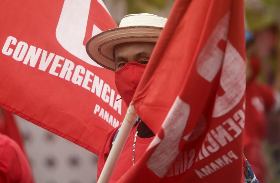 A man wearing a protective face mask amid the new coronavirus pandemic, takes part in a Panamanian Union workers' march, in the annual May Day parade in Panama City, Saturday, May 1, 2021. (AP Photo/Arnulfo Franco)