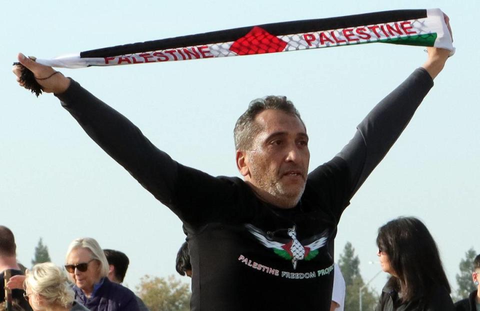 Thaer Jawhar of Fresno holds a pro-Palestine banner at the finish of the Two Cities Half Marathon on Nov. 5, 2023.