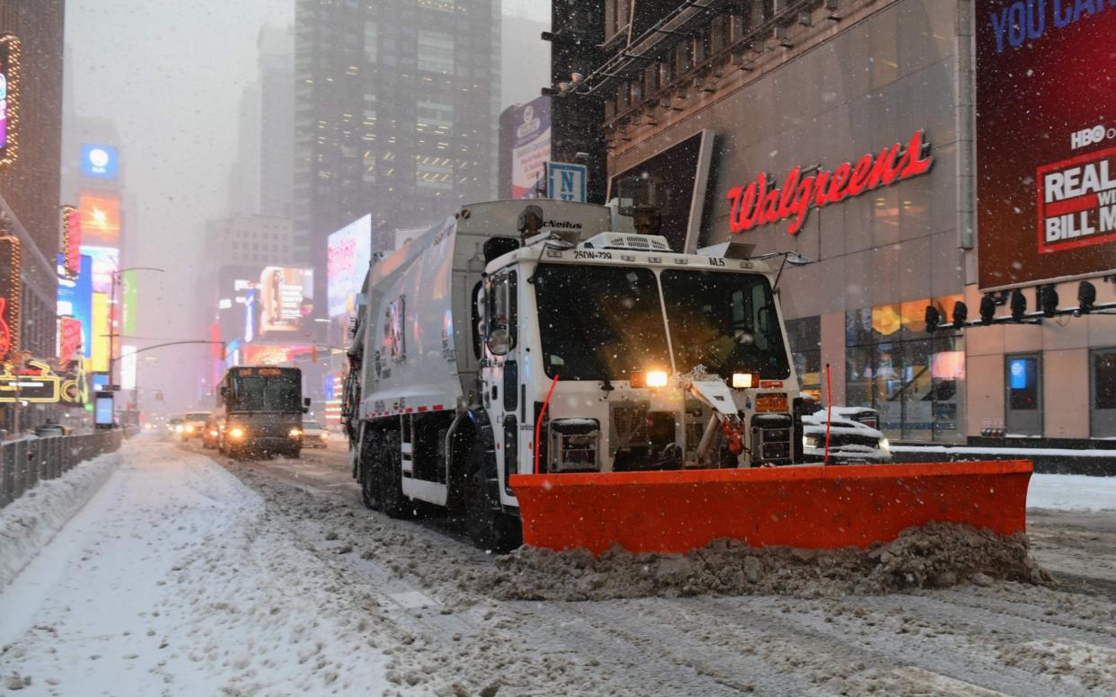 Snowplows drive through Times Square during a winter storm on February 1 - ANGELA WEISS /AFP