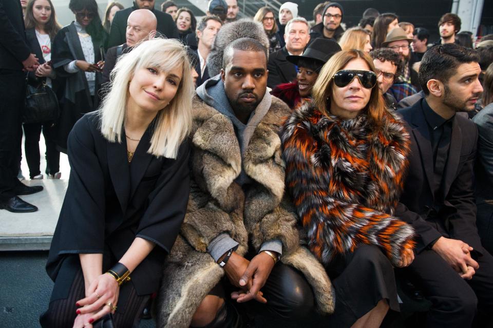 From left, actress Noomi Rapace, singer Kanye West and fashion editor Carine Roitfeld attend the Givenchy men's Fall-Winter 2014-2015 fashion collection, presented Friday, Jan. 17, 2014 in Paris. (AP Photo/Zacharie Scheurer)