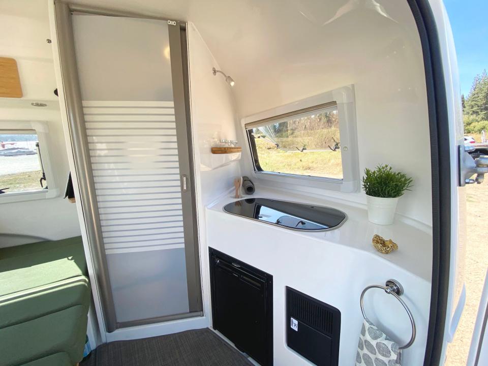 A kitchenette next to a closed bathroom door.