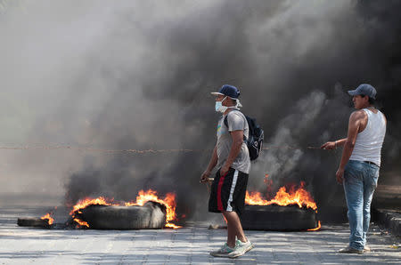 Demonstrators walk past a barricade as they take part during a protest over a controversial reform to the pension plans of the Nicaraguan Social Security Institute (INSS) in Managua, Nicaragua April 21, 2018. REUTERS/Oswaldo Rivas