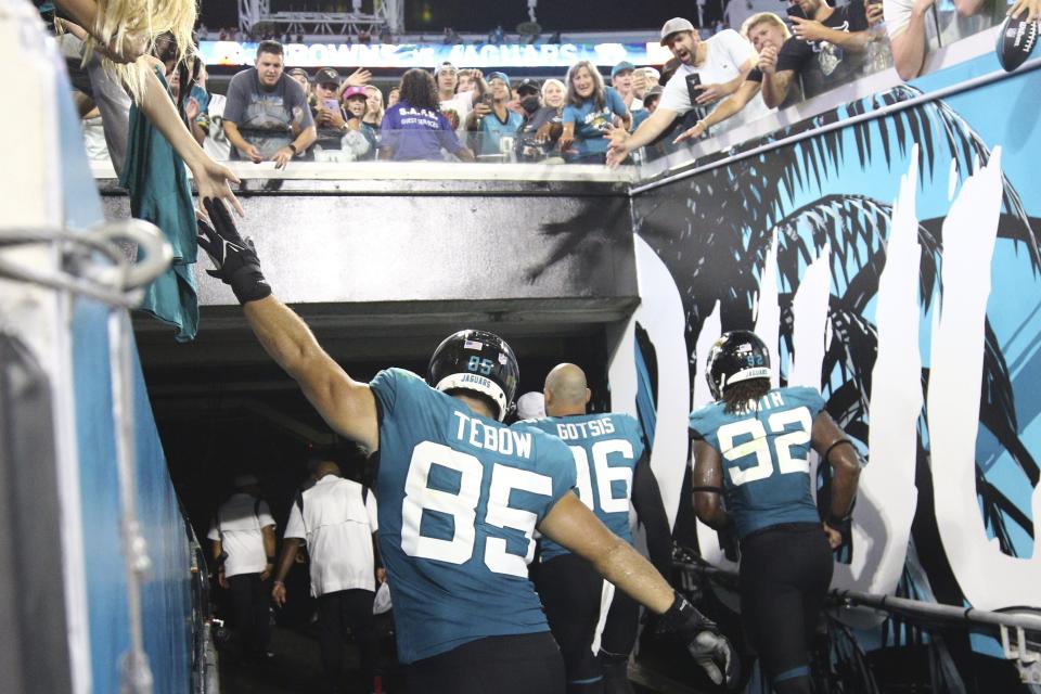 Tim Tebow (85) high fives fans after an preseason game against the Cleveland Browns on Aug. 14.