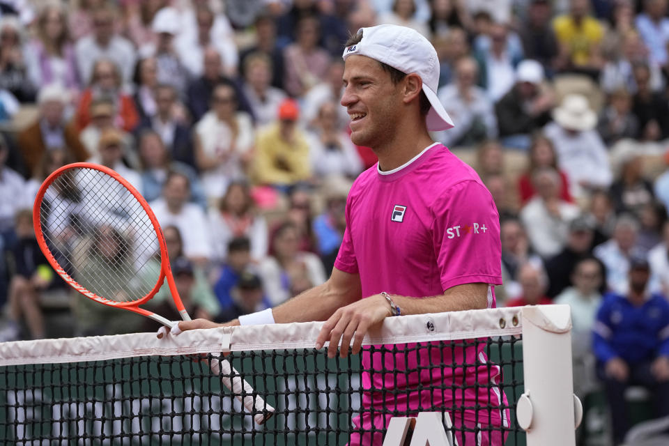 Argentina's Diego Schwartzman smiles at the net as he plays Bulgaria's Grigor Dimitrov during their third round match of the French Open tennis tournament at the Roland Garros stadium Friday, May 27, 2022 in Paris. (AP Photo/Michel Euler)