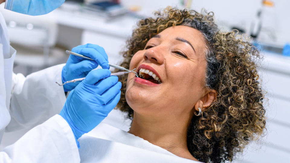 A woman in a dentist chair getting her mouth examined to get rid of canker sores fast