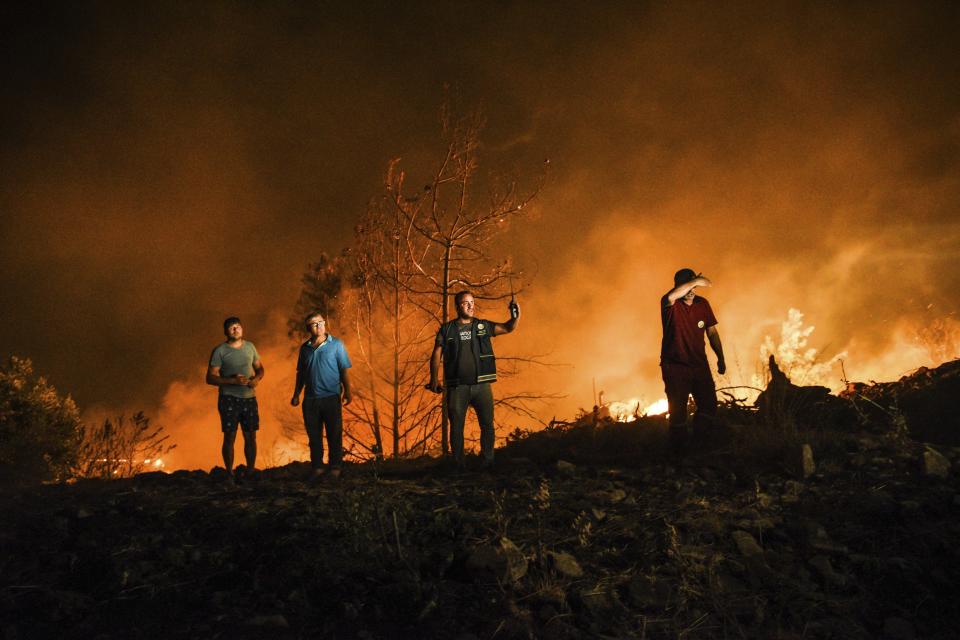 Firefighters and local villagers respond to a fire in Kirli village near the town of Manavgat, in Antalya province, Turkey, early Friday July 30, 2021. The fire that continued all night could not be brought under control and people living in the village started to evacuate. Wildfires are common in Turkey's Mediterranean and Aegean regions during the arid summer months, although some previous forest fires have been blamed on arson. (AP Photo)