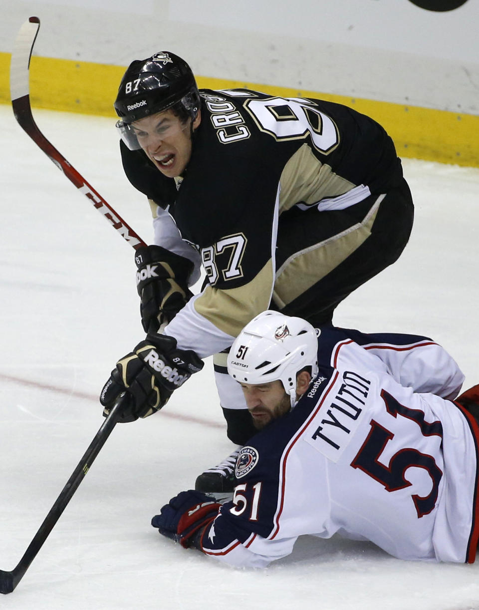 Pittsburgh Penguins' Sidney Crosby (87) collides with Columbus Blue Jackets' Fedor Tyutin (51) during the first period of a first-round NHL playoff hockey game in Pittsburgh on Wednesday, April 16, 2014. (AP Photo/Gene J. Puskar)