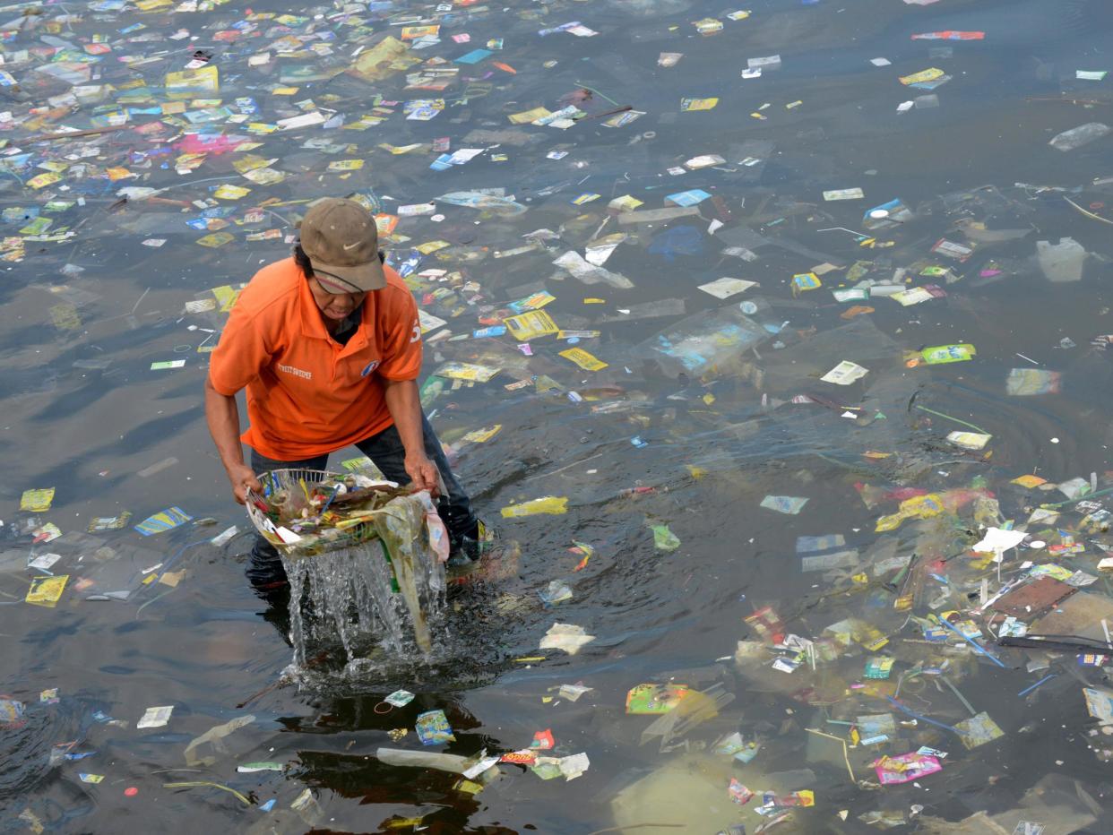 A worker cleaning up Manila Bay in the Philippines. Anywhere in the world, once plastic goes into the water it can be carried to the Arctic by ocean currents: Getty Images