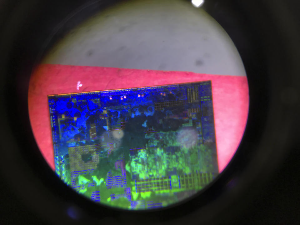 FILE - A Chinese microchip is seen through a microscope set up at the booth for the state-controlled Tsinghua Unigroup project which is driving China's semiconductor ambitions during the 21st China Beijing International High-tech Expo in Beijing, China, on May 17, 2018. Furious at U.S. efforts that cut off access to technology to make advanced computer chips, China's leaders appear to be struggling to figure out how to retaliate without hurting their own ambitions in telecoms, artificial intelligence and other industries. (AP Photo/Ng Han Guan, File)