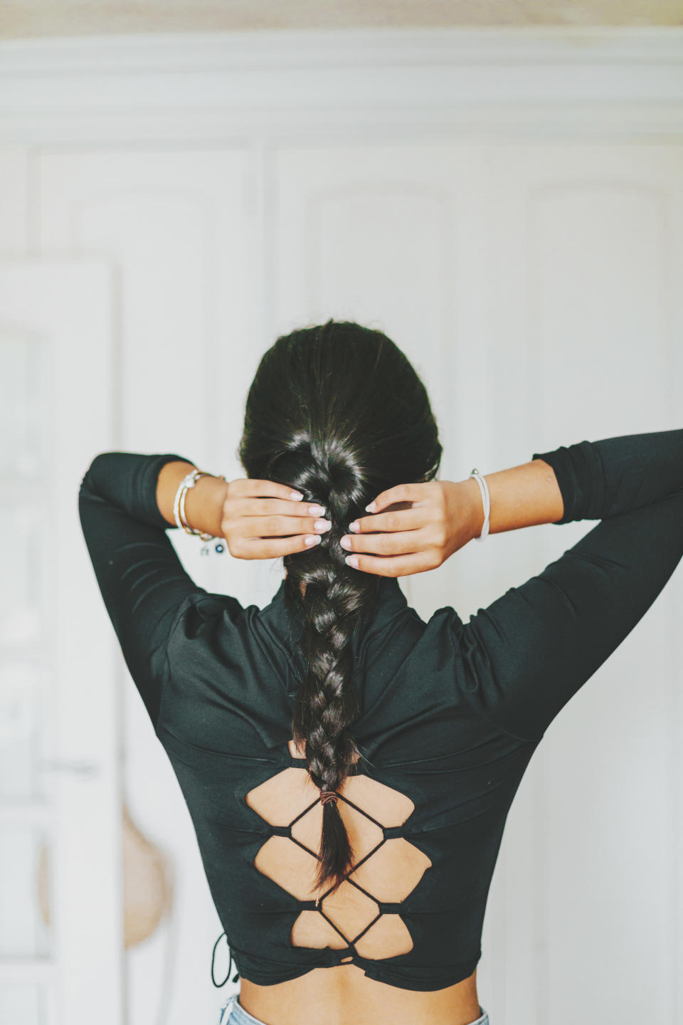 the back of a girl braiding her hair