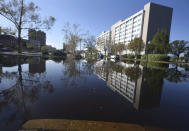 The Hotel Ballast is reflected in floodwaters from the Cape Fear River along Water St. in downtown Wilmington, N.C., Sunday, Sept. 23, 2018. The river is expected to crest on Monday night. (Matt Born/The Star-News via AP)