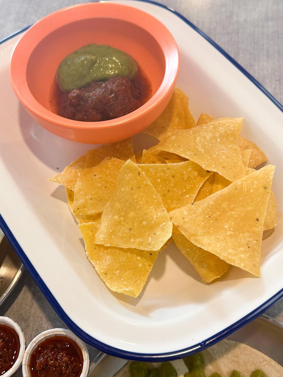 Corn chips with guacamole and a salsa for sides