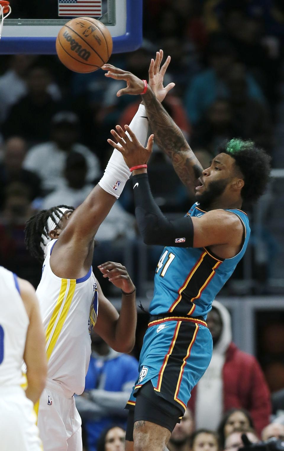 Detroit Pistons forward Saddiq Bey (41) passes against Golden State Warriors center Kevon Looney during the first half of an NBA basketball game Sunday, Oct. 30, 2022, in Detroit. (AP Photo/Duane Burleson)