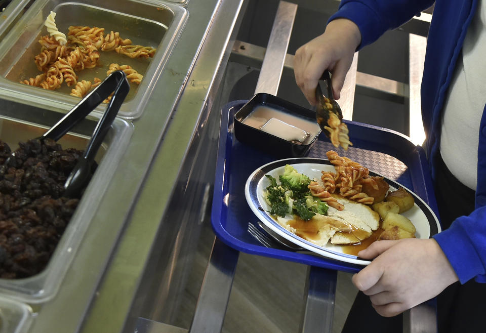 A general view of pupils during lunch hour at Hillstone Primary School, in Birmingham, England, Wednesday, Nov. 30, 2022. For some children in low-income areas in England, a school lunch may be the only nutritious hot meal they get in a day. School lunches are given for free to all younger children in England and to some of the poorest families. But the Food Foundation charity estimates that there are 800,000 children in England living in poverty who are not eligible for the free meals. (AP Photo/Rui Vieira)