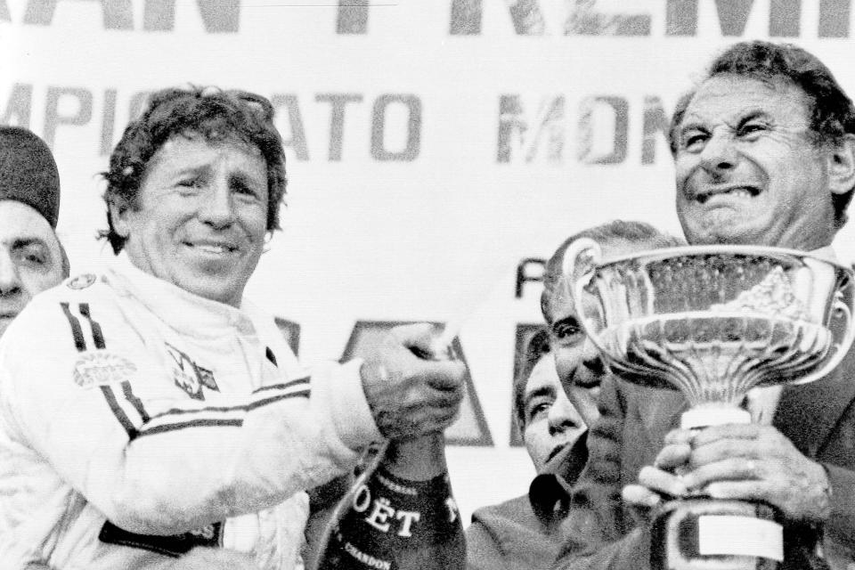 FILE - Mario Andretti, left, of Nazareth, Pa., sprays champagne on the crowd as he is presented with the Formula 1 world auto racing championship cup after the Grand Prix of Italy at Monza, Sept. 11, 1978. American Michael Andretti cleared a major hurdle in his bid to launch a Formula One team as the FIA said Monday, Oct. 2, 2023, that he meets all required criteria to expand the world's top motorsports series to 11 teams. The father and son have been trying for years to get the Andretti name back into F1. Man holding cup in unidentified. (AP Photo/File)