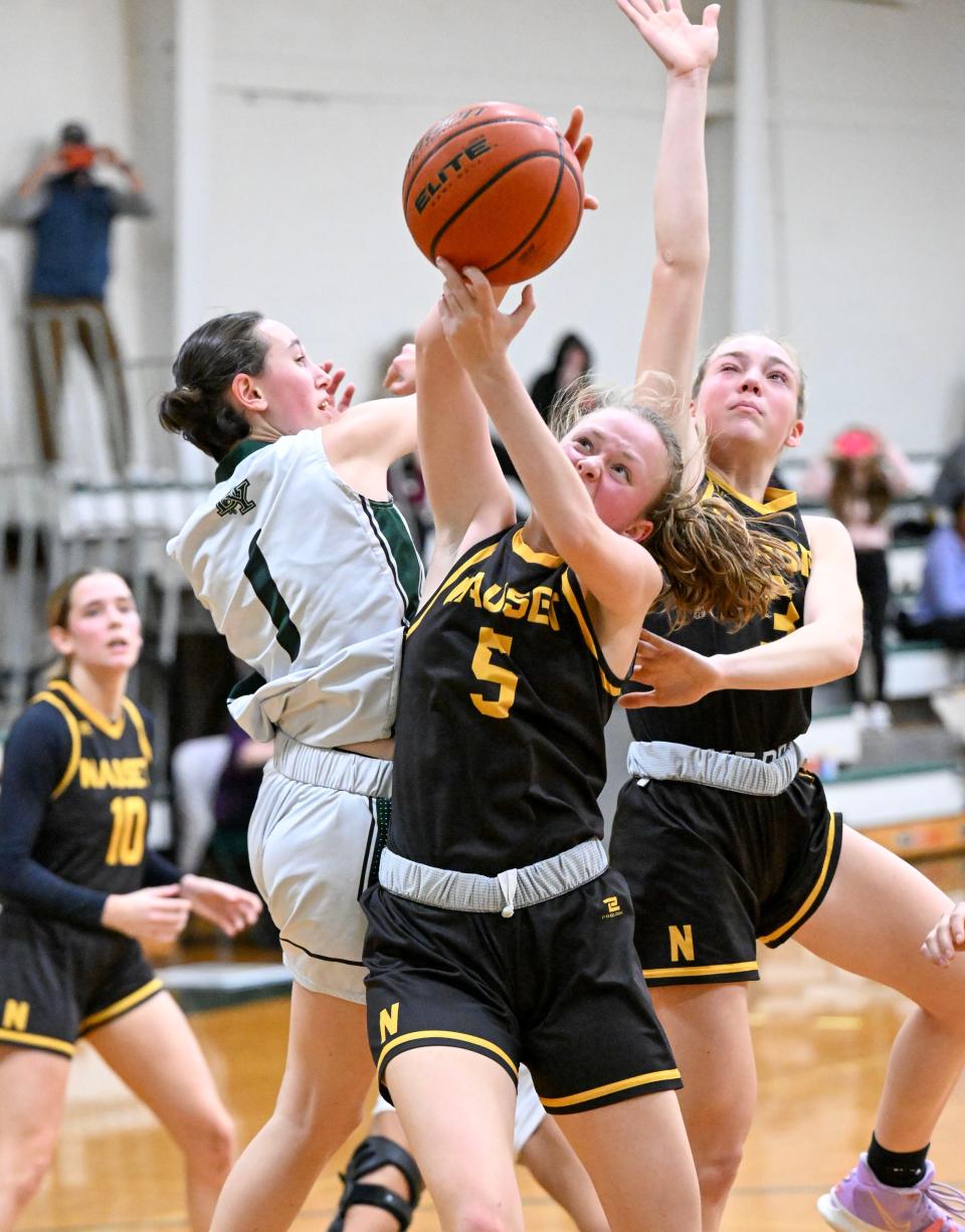 In Thursday girls basketball game action, Sammy McIsaac of Nauset grabs a loose ball from Siena Lauze of Dennis-Yarmouth. D-Y defeated Nauset 61-36.