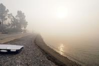 Smoke spreads over a beach during a wildfire in Limni village on the island of Evia, about 160 kilometers (100 miles) north of Athens, Greece, Thursday, Aug. 5, 2021. Forest fires fueled by a protracted heat wave raged overnight and into Thursday in Greece, threatening the archaeological site at the birthplace of the modern Olympics and forcing the evacuation of dozens of villages. (AP Photo/Thodoris Nikolaou)