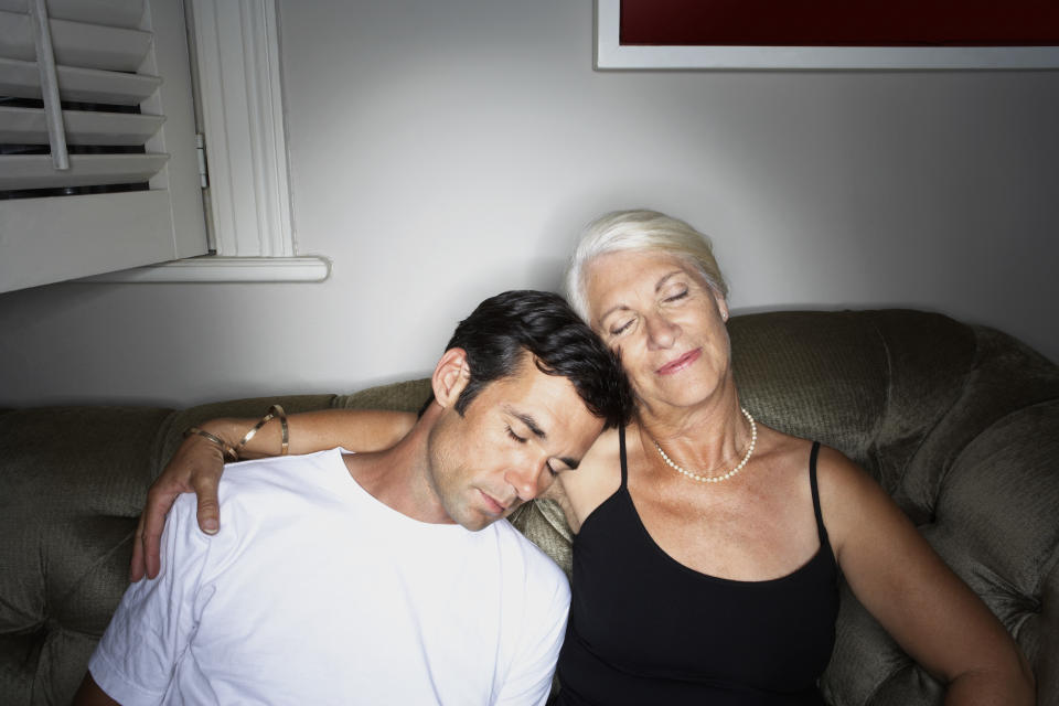 A mature woman wraps her arm around a younger man. (Photo: Getty Images)