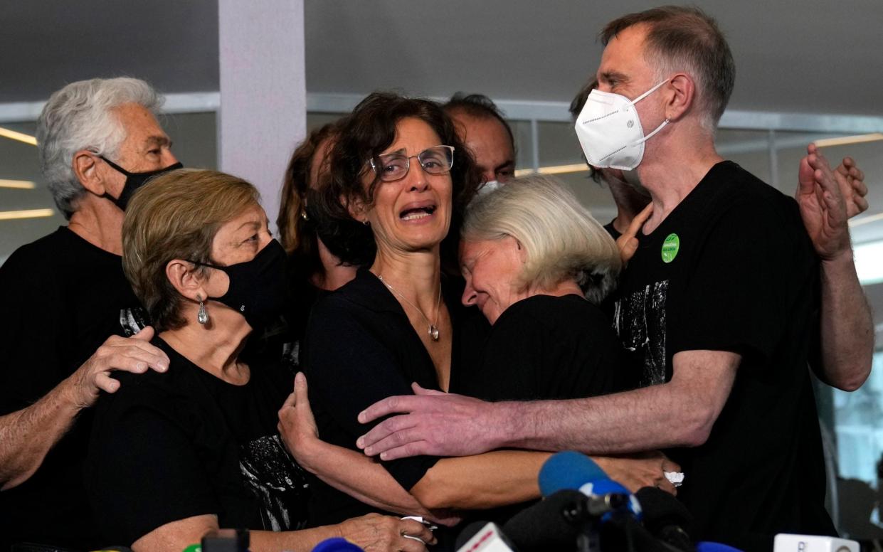 Alessandra Sampaio, centre, embraces her sister-in-law Sian Phillips after speaking to the media during the funeral of her husband Dom Phillips - AP