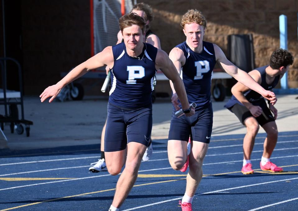 Petoskey's Sam Mitas (front) receives the baton from teammate Mason Fralick during the 4x100 meter relay on Wednesday at Northmen Stadium.