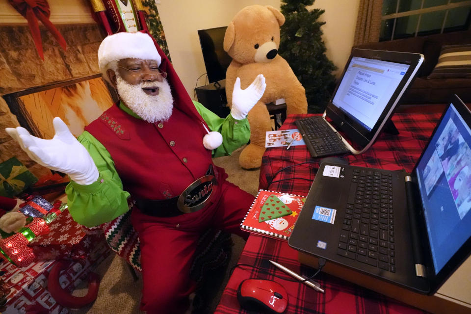 Larry Jefferson portrays Santa Claus and conducts a visit via a computer screen with Raquel Anaya and her cousins Lexi and Luna Reyes from his home in Duncanville, Texas, on Dec. 9, 2020. The children lost a grandmother to COVID-19 recently. In this socially distant holiday season, Santa Claus is still coming to towns (and shopping malls) across America but with a few 2020 rules in effect. (AP Photo/LM Otero)