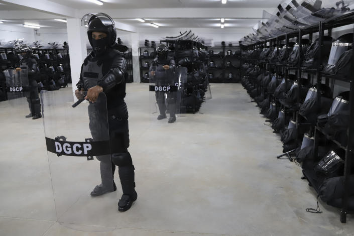 National Civil Police from the anti-riot unit stand in the weapons and equipment area of the Terrorism Confinement Center during a media tour in Tecoluca, El Salvador, Thursday, Feb. 2, 2023. The "mega-prison" still under construction has a maximum capacity of 40,000 and is intended to imprison gang members, according to the government. (AP Photo/Salvador Melendez)