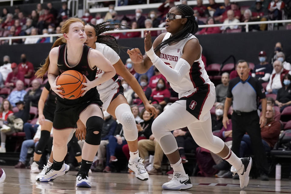 Santa Clara guard Tess Heal, left, drives to the basket against Stanford forward Francesca Belibi, right, and guard Haley Jones during the first half of an NCAA college basketball game in Stanford, Calif., Wednesday, Nov. 30, 2022. (AP Photo/Jeff Chiu)