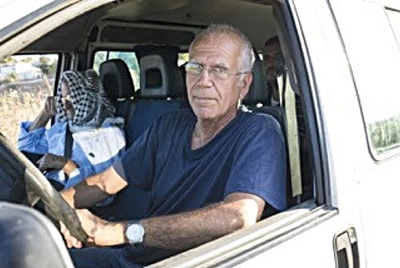 Yuval Roth, founder of the charity, pictured driving Palestinians to medical appointments