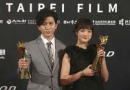 Taiwanese actress Gingle Wang, right, and Taiwanese actor Mo Tzu-yi hold their awards for Best Actress and Best Actor at the 2020 Taipei Film Festival in Taipei, Taiwan, Saturday, July 11, 2020. The 2020 Taipei Film Festival is the world's first large-scale film festival held by an entity after the outbreak of the COVID-19 epidemic. (AP Photo/Chiang Ying-ying)