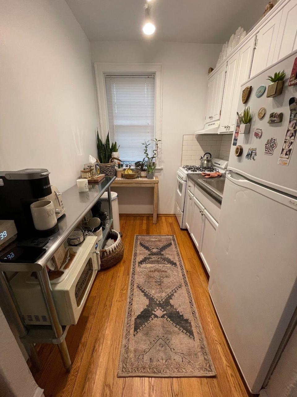 The writer's small kitchen, with a runner rug down the wood floors and appliances on the thin counter