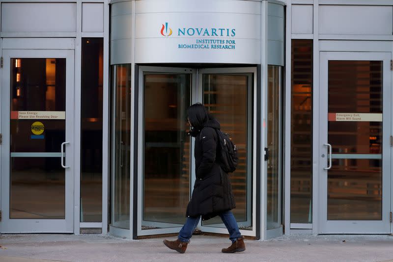 FILE PHOTO: A pedestrian passes Novartis' Institutes for Biomedical Research in Cambridge