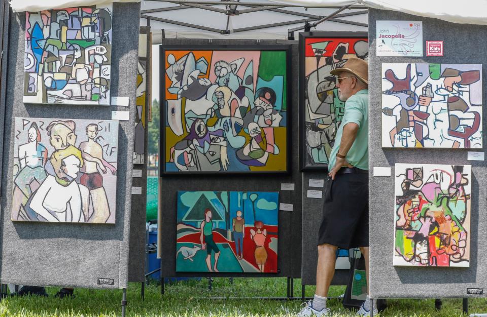 A Mayfaire visitor looks over the abstract art of John Jacopella.