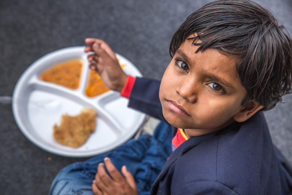 Indian school children eat their free midday meal at a government school in Haryana