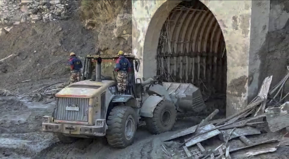 This grab from video provided by Indo Tibetan Border Police (ITBP) shows ITBP personnel using machinery to clear muck as they try to rescue more than three dozen power plant workers trapped in a tunnel after part of a Himalayan glacier broke off Sunday and sent a wall of water and debris rushing down the mountain in Tapovan area of the northern state of Uttarakhand, India, Monday, Feb.8, 2021. (Indo Tibetan Border Police via AP)