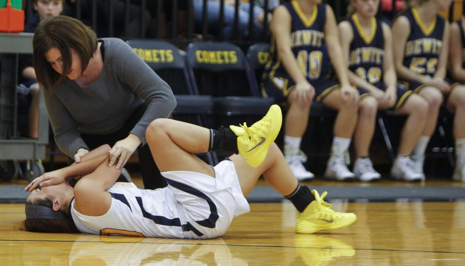 Grand Ledge athletic trainer Heather Kleiman tends to sophomore Sophia Guzman, competing against DeWitt, Friday, Dec. 6, 2013. Kleiman died Monday, according to school officials.