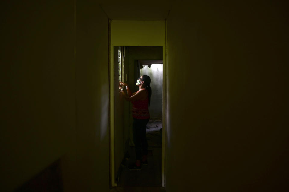 Marian Colon, a single mother of two sons, inspects her home damaged during the hurricane season nearly three years ago, in Guaynabo, Puerto Rico, Tuesday, July 14, 2020. After Hurricane Maria tore through Puerto Rico, not a single home has been rebuilt for the nearly 27,000 people who applied for the federally funded program known as R3 for its efforts to repair, rebuild or relocate. (AP Photo/Carlos Giusti)