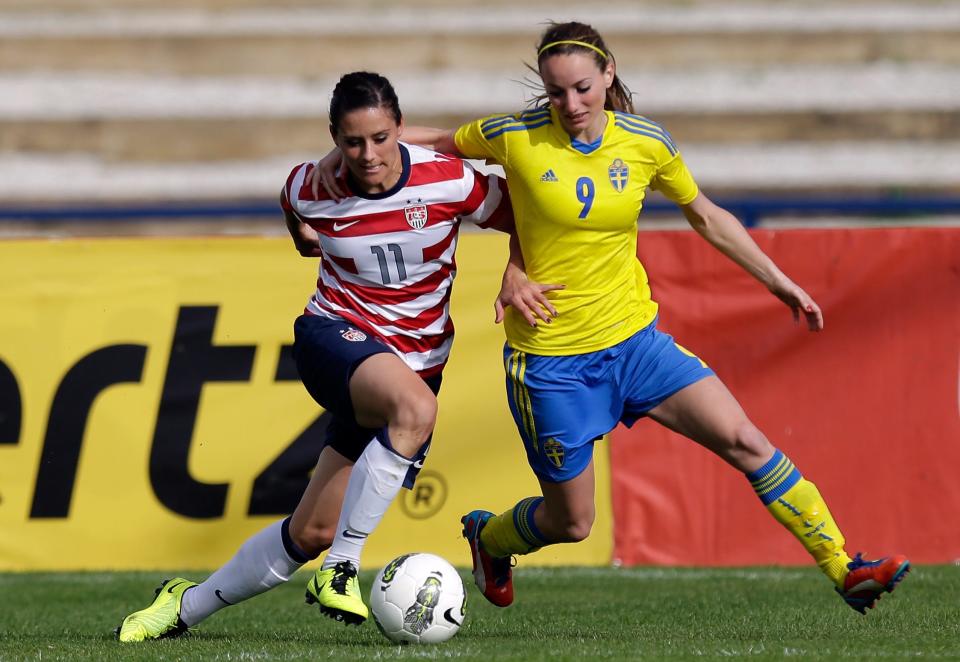 Ali Krieger (left) wins the ball from Sweden's Kosovare Asllani during their 2013 Algarve Cup match.