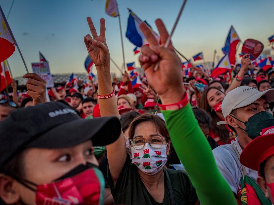 Supporters flash the peace sign, the campaign symbol of Ferdinand "Bongbong" Marcos Jr., during his last campaign rally before the election on May 07, 2022 in Paranaque, Metro Manila, Philippines.