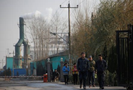 Smoke billows from a chimney as workers leave a factory in rural Gaoyi county, known for its ceramics production, near Shijiazhuang, Hebei province, China, December 7, 2017. REUTERS/Thomas Peter