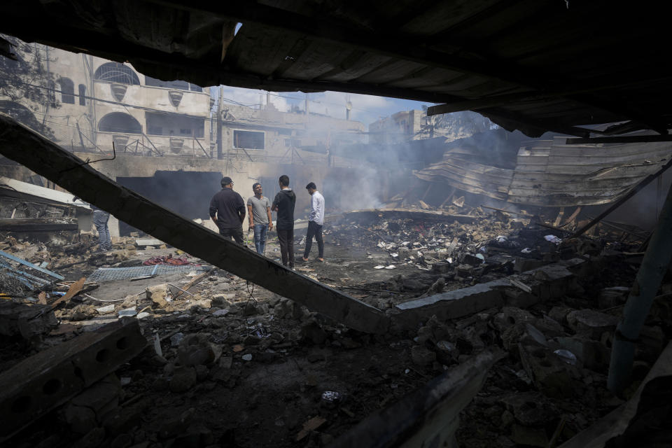 Palestinians look at the destruction after an Israeli strike on a school run by UNRWA, the U.N. agency helping Palestinian refugees, in Nuseirat, Gaza Strip, Tuesday, May 14, 2024. (AP Photo/Abdel Kareem Hana)