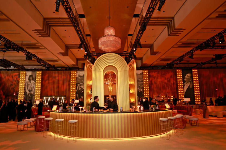 Guests at a circular bar with an arch backdrop in an elegant event setting