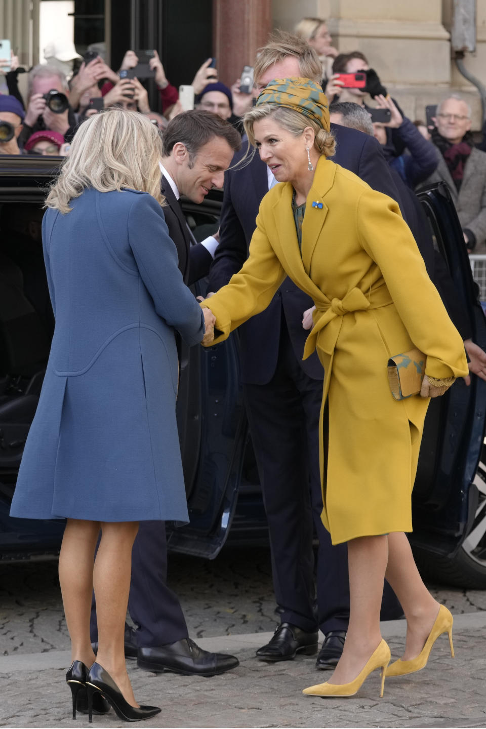 French President Emmanuel Macron's wife Brigitte Macron is welcomed by Dutch Queen Maxima, right, outside the royal palace on Dam square in Amsterdam, Netherlands, Tuesday, April 11, 2023. French President Emmanuel Macron begins a two-day state visit to the Netherlands on Tuesday and is making a speech on his vision for the future of Europe. (AP Photo/Peter Dejong)