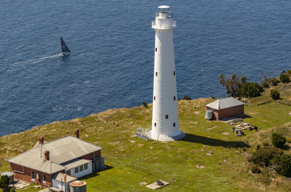 In this photo provided by Rolex/Studio Borlenghi, supermaxi Wild Oats XI sails past a lighthouse on the island state of Tasmania as they get close to Hobart, Australia, on the way to winning line honors in the Sydney Hobart yacht race, Friday, Dec. 28, 2018. (Carlo Borlenghi/Rolex/Studio Borlenghi via AP)