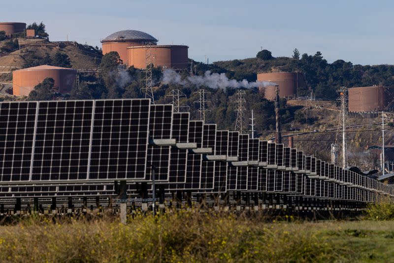 FILE PHOTO: Solar panels are see next to a Chevron refinery in Richmond