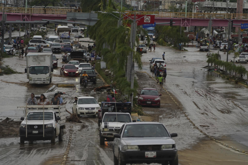 Cars cross a flood-damaged avenue after Hurricane Otis ripped through Acapulco, Mexico, Wednesday, Oct. 25, 2023. Hurricane Otis ripped through Mexico's southern Pacific coast as a powerful Category 5 storm, unleashing massive flooding, ravaging roads and leaving large swaths of the southwestern state of Guerrero without power or cellphone service. (AP Photo/Marco Ugarte)