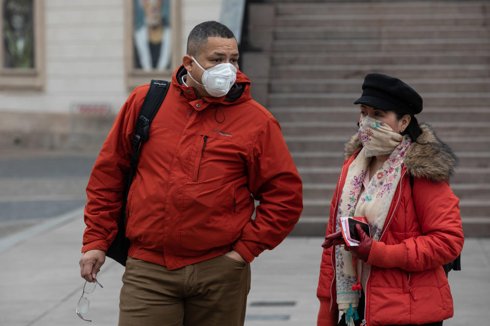 MILAN, ITALY - FEBRUARY 25: Two people, both wearing a respiratory mask, stand in Piazza del Duomo on February 25, 2020 in Milan, Italy. Italy is the last country to be hit hard by the virus with 7 dead and more than 283 infected as of today. The spread marks Europe’s biggest outbreak, prompting the Italian Government to issue draconian safety measures. (Photo by Emanuele Cremaschi/Getty Images)